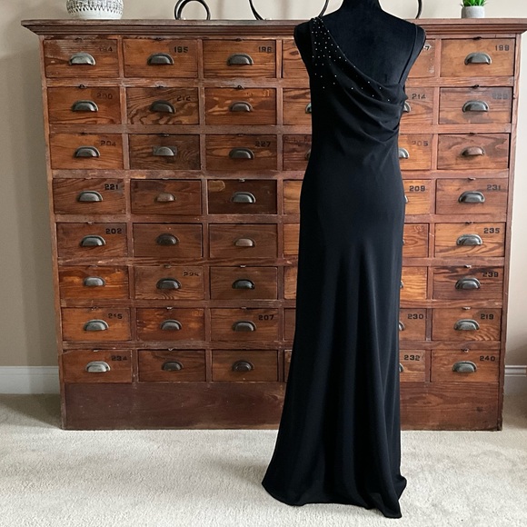 Black slim line evening gown with sparkle accent on left side shoulder. - Picture 2 of 5